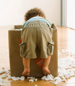Toddler with cardboard box and packing peanuts